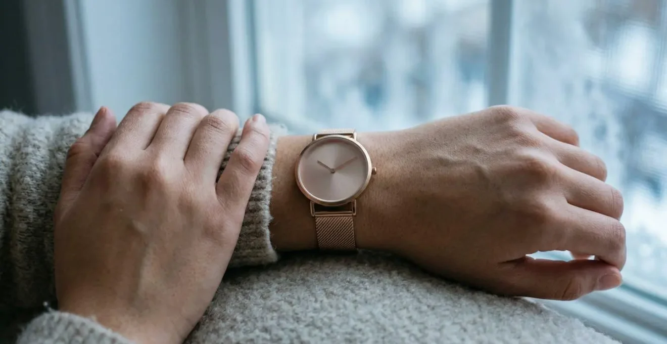 Poignet avec montre en or rose sous lumière naturelle d'hiver montrant l'harmonie des tons