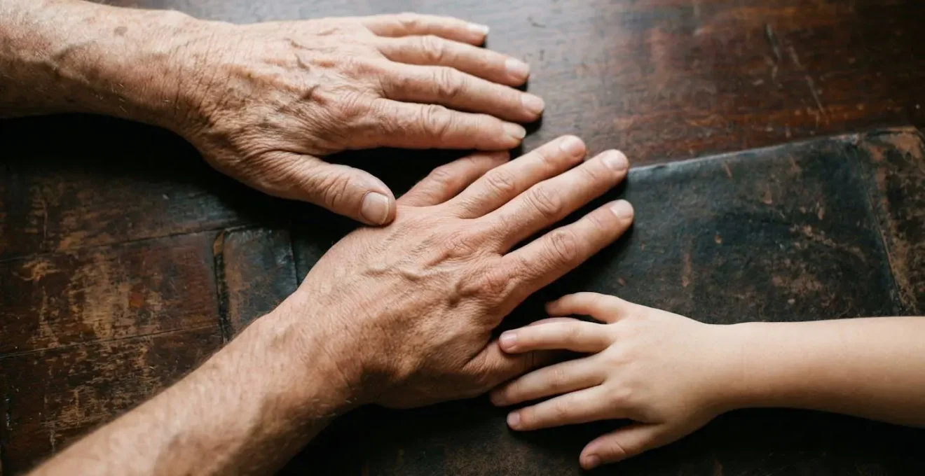 Trois mains masculines d'âges différents en perspective suggérant transmission intergénérationnelle