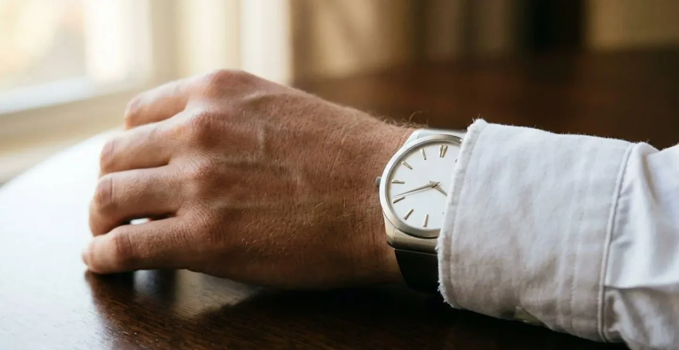Montre extra-plate en platine sur poignet masculin, cadran épuré sans complications